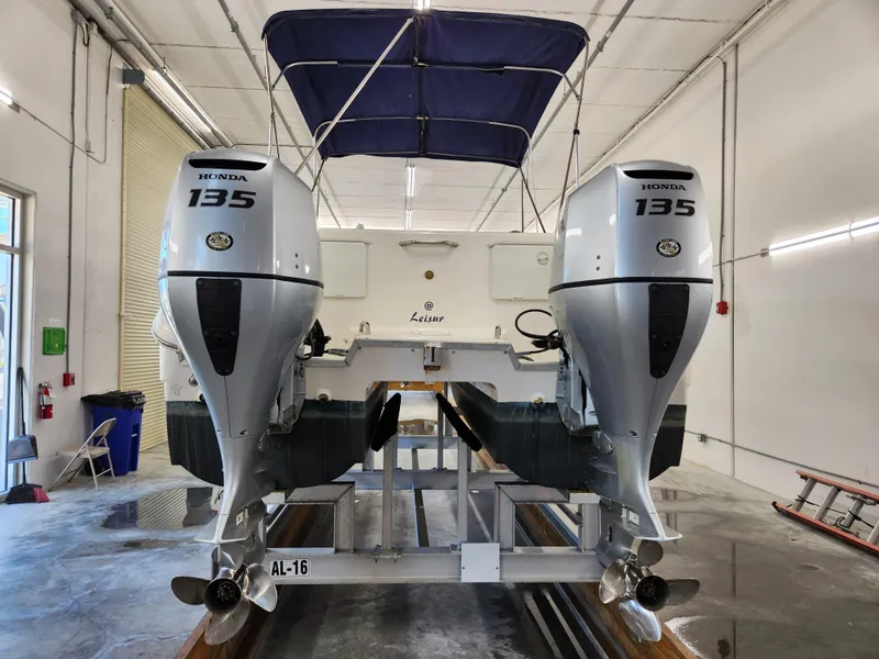 Slide: The Image of 2000 World Cat 266 Leisure Cat with dual Honda 135 engines in a garage setting. - 5