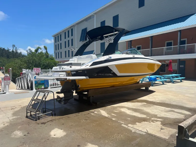 Slide: The Image of 2013 Regal 24 FasDeck RX boat on dock, yellow hull, sunny day. - 3
