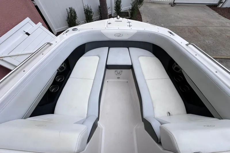 Slide: The Image of 2013 Regal 24 FasDeck RX boat interior with white cushioned seating and cup holders. - 31