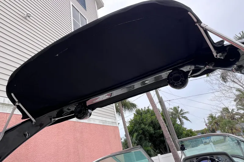 Slide: The Image of 2013 Regal 24 FasDeck RX boat canopy with speakers, near a house and palm trees. - 38