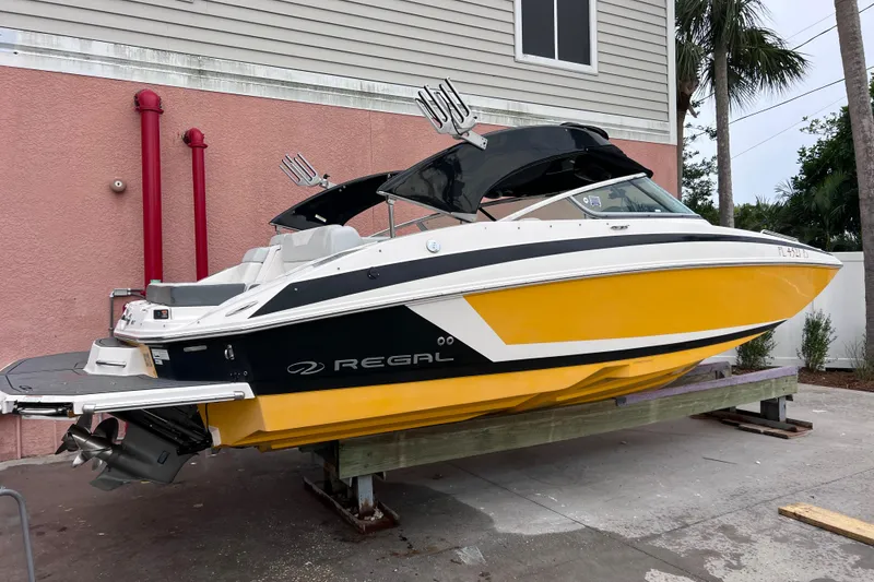 Slide: The Image of 2013 Regal 24 FasDeck RX boat with yellow hull, docked outdoors. - 46