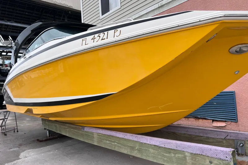Slide: The Image of Yellow 2013 Regal 24 FasDeck RX boat on a lift, side view. - 48