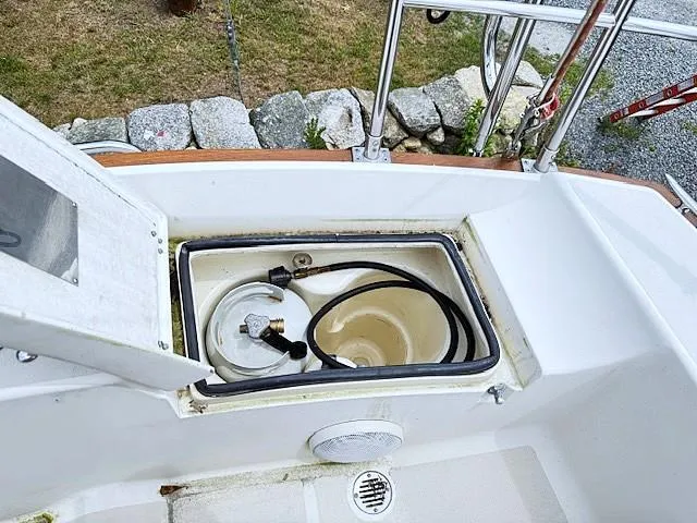 Slide: The Image of Open storage compartment on a 1993 Tartan 3500 sailboat deck, containing a hose and equipment. - 17