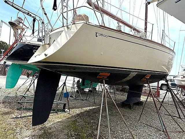 Slide: The Image of 1993 Tartan 3500 sailboat on stands, displayed in a boatyard. - 2