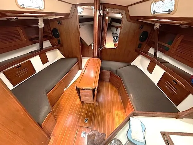 Slide: The Image of Interior of a 1993 Tartan 3500 sailboat with wooden furnishings and cozy seating. - 21