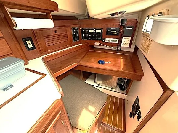 Slide: The Image of Navigation station in a 1993 Tartan 3500 sailboat with wooden interior and control panels. - 22