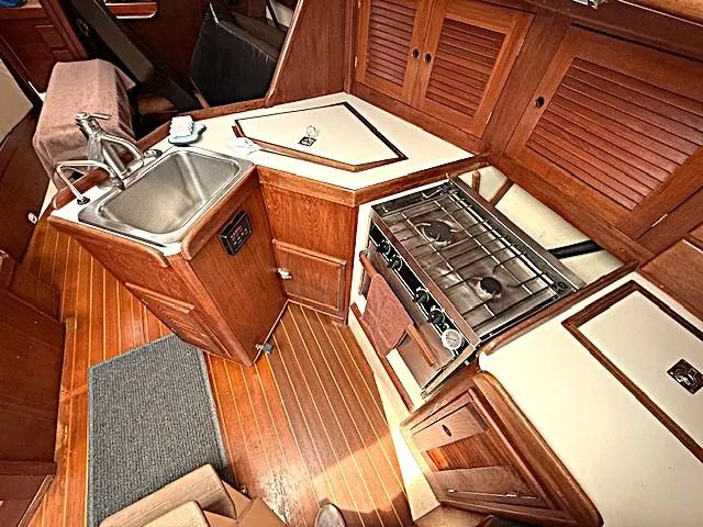 Slide: The Image of 1993 Tartan 3500 yacht kitchen with wooden cabinetry, stainless steel sink, and stove. - 24