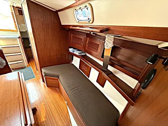 Slide: The Image of Interior of a 1993 Tartan 3500 sailboat with wooden furnishings and cozy seating. - 26
