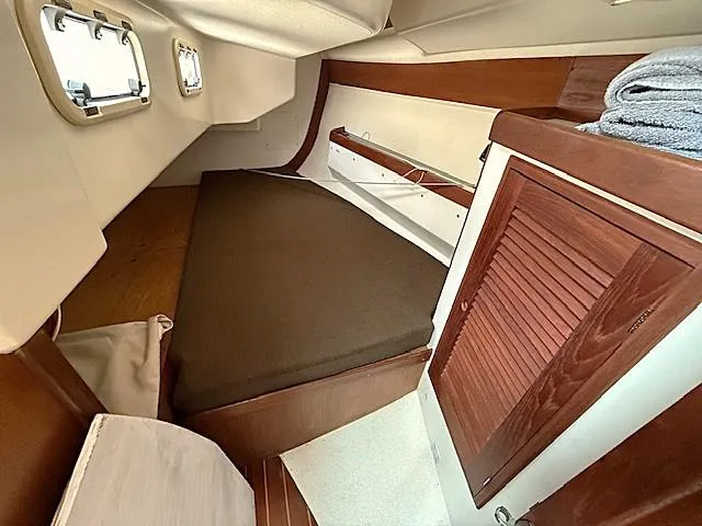 Slide: The Image of Cozy cabin interior of 1993 Tartan 3500 sailboat with wooden accents and bedding. - 28
