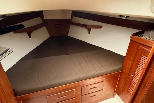 Slide: The Image of Cozy cabin interior of a 1993 Tartan 3500 sailboat with wooden storage and bed. - 30