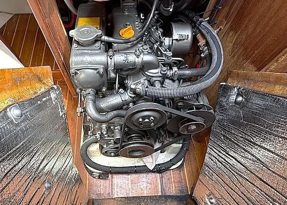 Slide: The Image of Engine compartment of a 1993 Tartan 3500 sailboat, showcasing mechanical components and wooden paneling. - 32