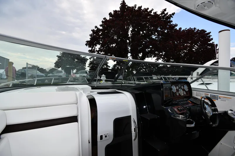 Slide: The Image of 2014 Rinker 310 Express Cruiser cockpit with steering wheel and dashboard controls. - 11