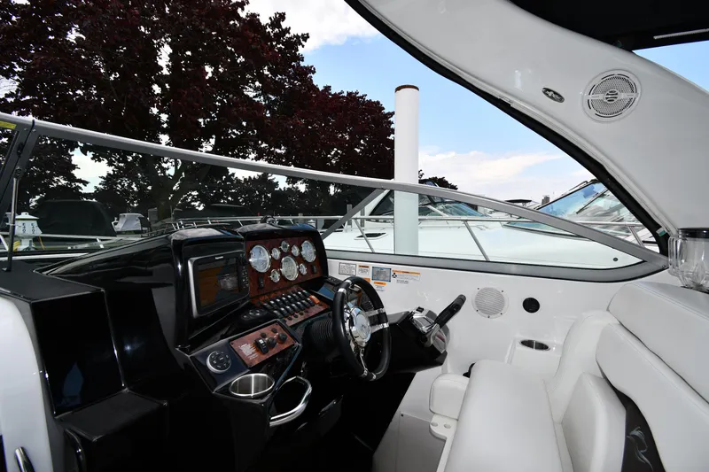 Slide: The Image of 2014 Rinker 310 Express Cruiser cockpit with modern controls and comfortable seating. - 12