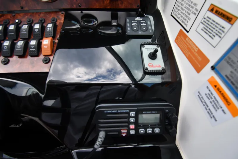 Slide: The Image of Control panel of a 2014 Rinker 310 Express Cruiser with switches and radio. - 16