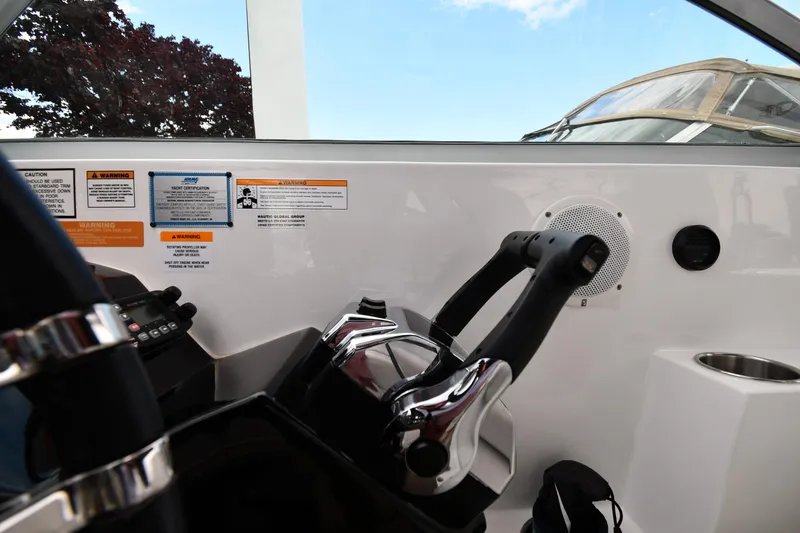 Slide: The Image of 2014 Rinker 310 Express Cruiser helm with controls and warning labels. - 17