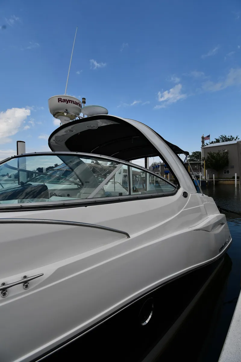 Slide: The Image of 2014 Rinker 310 Express Cruiser docked under a clear blue sky. - 2