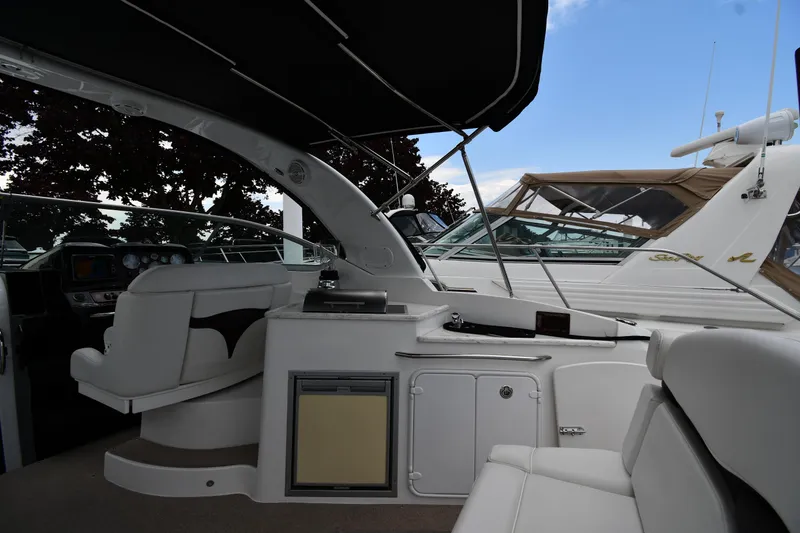Slide: The Image of 2014 Rinker 310 Express Cruiser interior with seating and dashboard, under a canopy. - 20