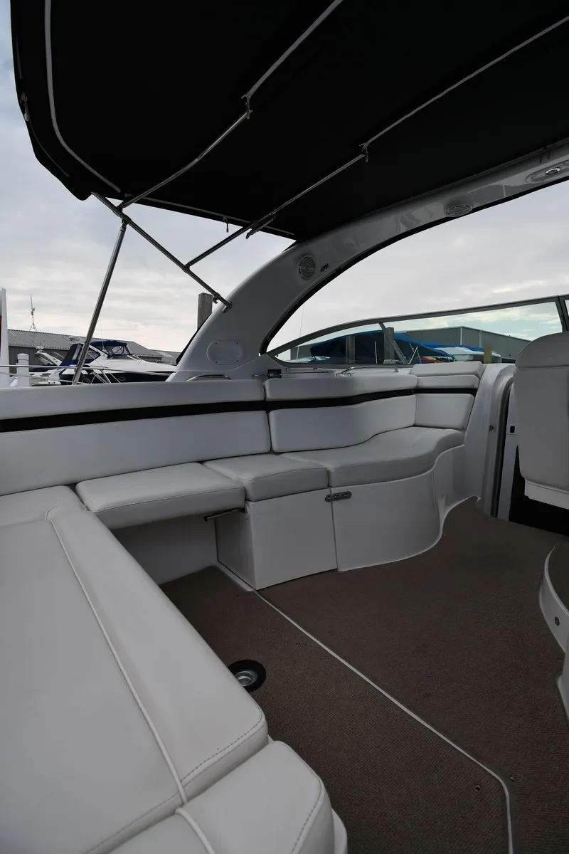 Slide: The Image of 2014 Rinker 310 Express Cruiser interior with white seating and canopy. - 23