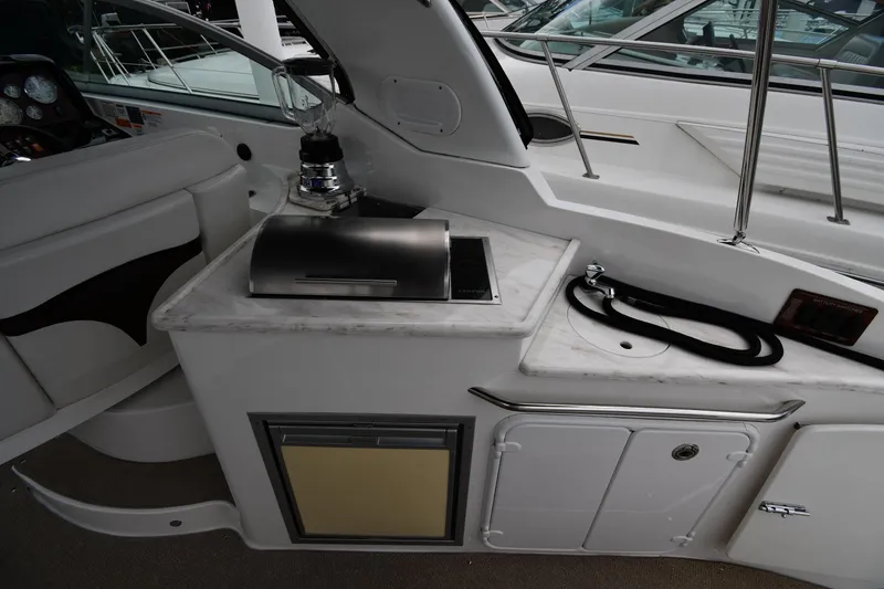 Slide: The Image of 2014 Rinker 310 Express Cruiser interior with kitchenette and seating area. - 26