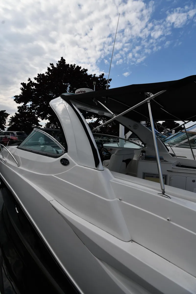 Slide: The Image of 2014 Rinker 310 Express Cruiser boat under a partly cloudy sky. - 3