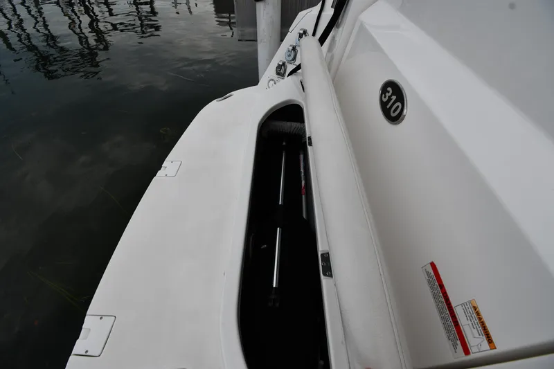 Slide: The Image of 2014 Rinker 310 Express Cruiser storage compartment by the water. - 32