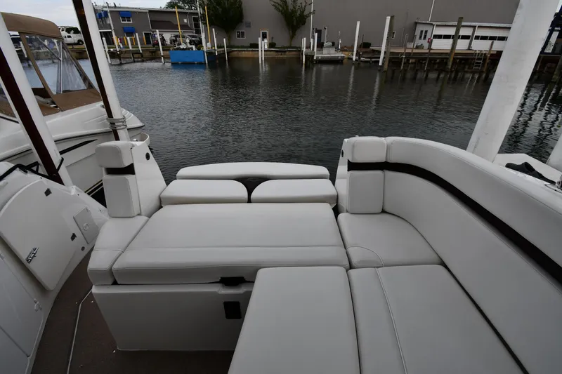 Slide: The Image of 2014 Rinker 310 Express Cruiser with white seating, docked at a marina. - 34