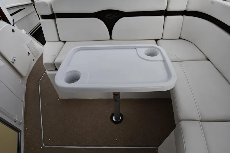 Slide: The Image of 2014 Rinker 310 Express Cruiser interior with white seating and table. - 35