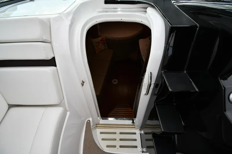 Slide: The Image of 2014 Rinker 310 Express Cruiser cabin entrance with white seating and black steps. - 36