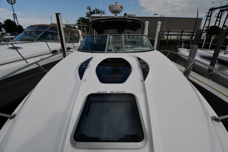 Slide: The Image of 2014 Rinker 310 Express Cruiser docked at marina, showcasing sleek design and spacious deck. - 4