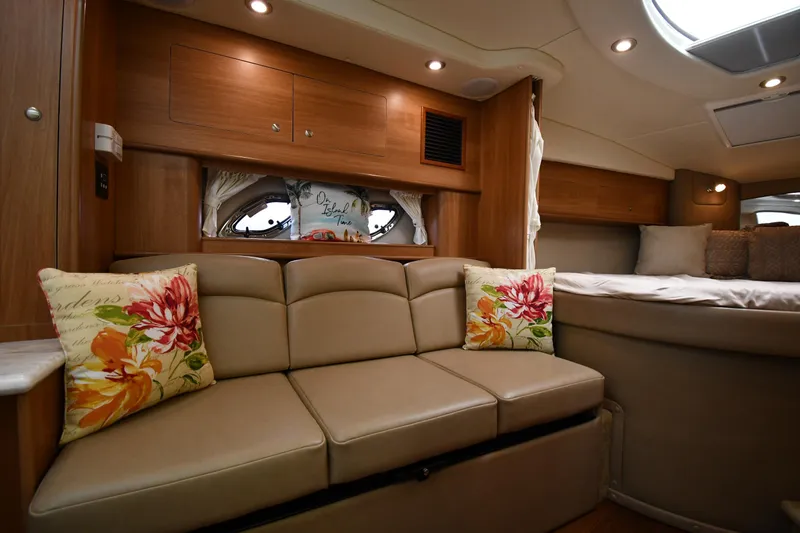 Slide: The Image of Interior of 2014 Rinker 310 Express Cruiser with beige sofa and floral pillows. - 44