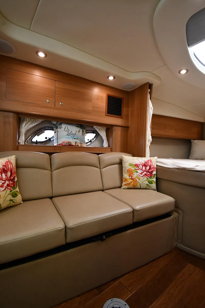 Slide: The Image of 2014 Rinker 310 Express Cruiser interior with beige seating and floral cushions. - 45