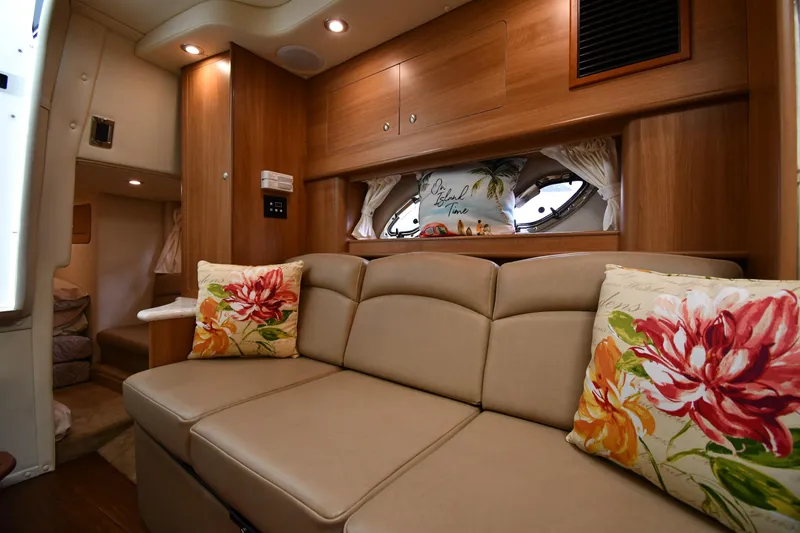 Slide: The Image of Interior of 2014 Rinker 310 Express Cruiser with beige sofa and floral pillows. - 46