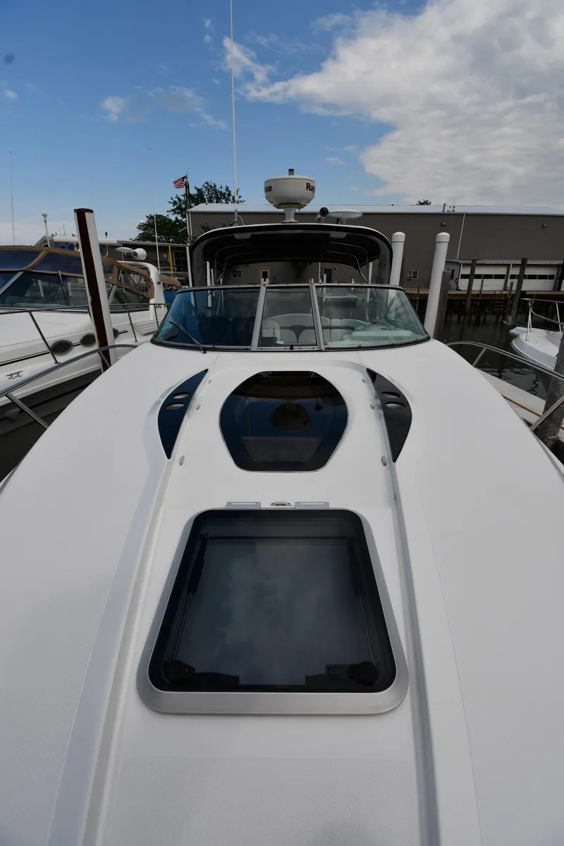 Slide: The Image of 2014 Rinker 310 Express Cruiser boat docked under a partly cloudy sky. - 5