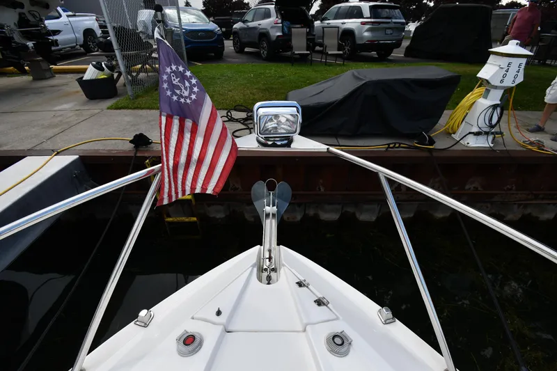 Slide: The Image of 2014 Rinker 310 Express Cruiser bow with American flag at dockside. - 6