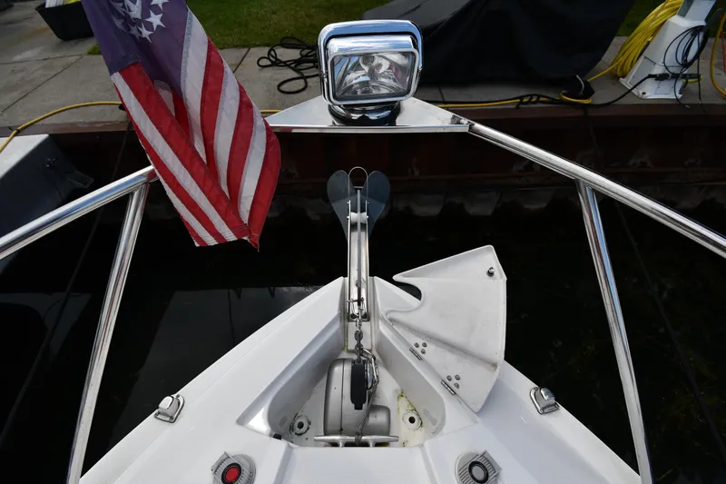 Slide: The Image of 2014 Rinker 310 Express Cruiser bow with American flag and anchor. - 7