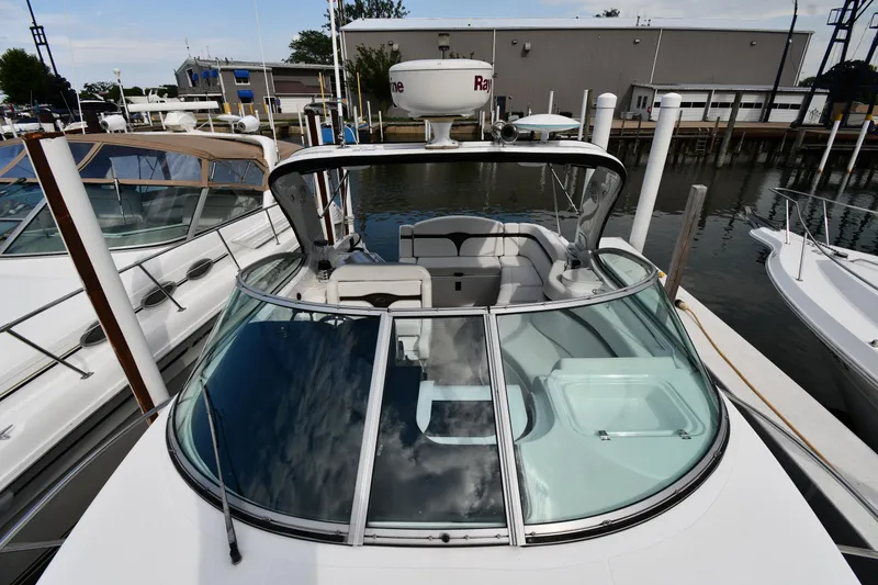 Slide: The Image of 2014 Rinker 310 Express Cruiser docked at marina, showcasing sleek design and spacious cockpit. - 8