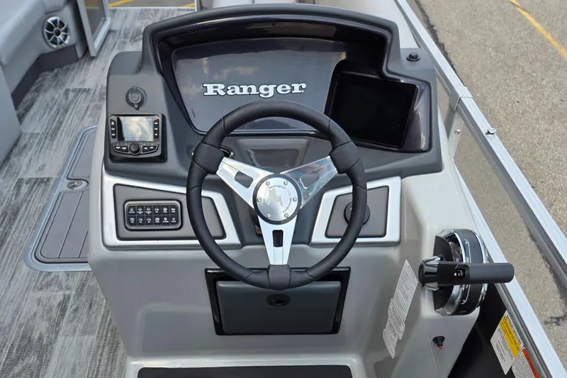 Slide: The Image of 2024 Ranger Reata 223C boat dashboard with steering wheel and control panel. - 4