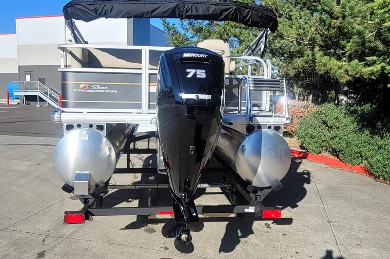 Slide: The Image of 2025 Sun Tracker Party Barge 18 DLX with Mercury 75 engine, parked outdoors. - 2