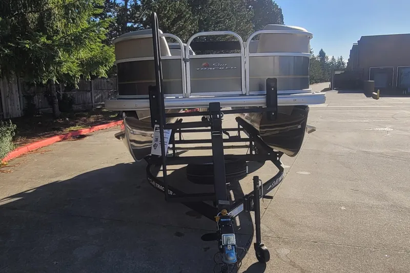 Slide: The Image of 2025 Sun Tracker Party Barge 18 DLX on trailer, parked outdoors. - 3