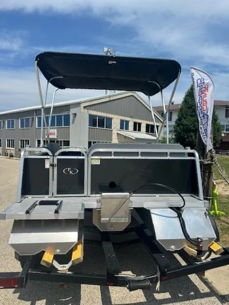 Slide: The Image of 2026 Paddle King Lo Pro Cruiser pontoon boat on trailer, sunny day, outdoor setting. - 2