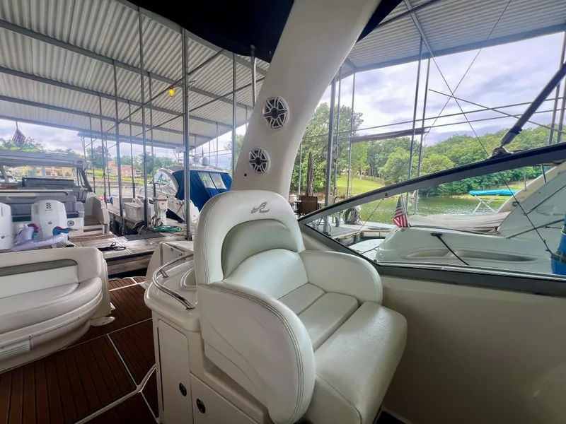 Slide: The Image of 2006 Sea Ray 340 Sundancer interior with white seating, docked at marina. - 11