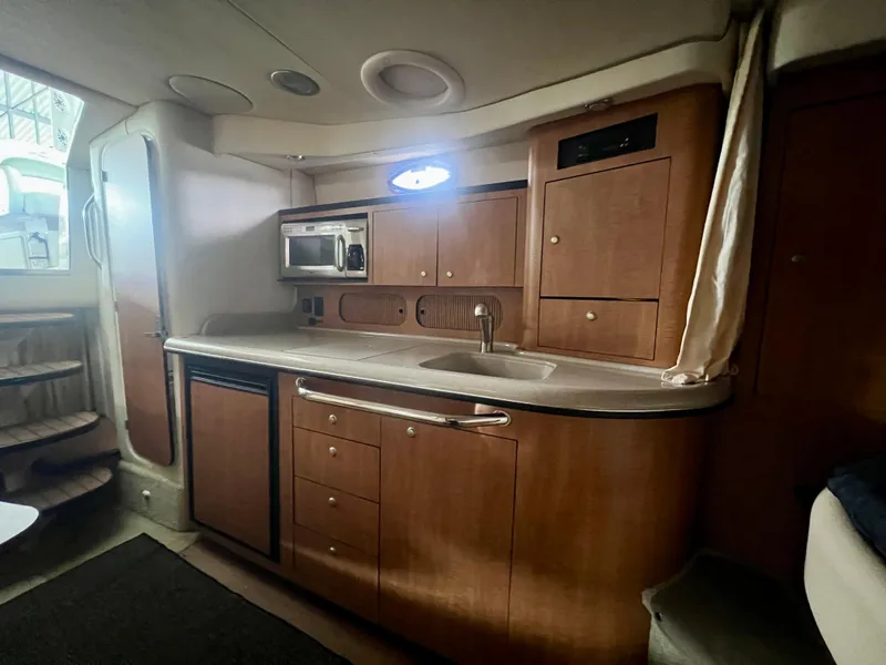 Slide: The Image of 2006 Sea Ray 340 Sundancer interior kitchen with wood cabinets and modern appliances. - 18