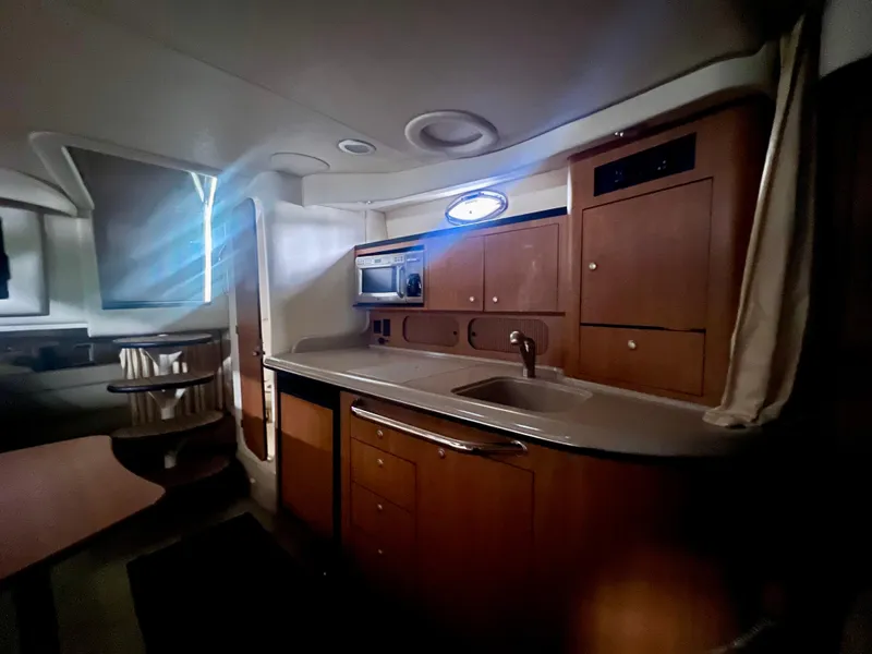 Slide: The Image of Interior of 2006 Sea Ray 340 Sundancer yacht with kitchenette and wooden cabinetry. - 21