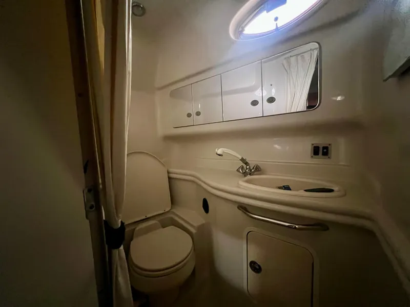 Slide: The Image of 2006 Sea Ray 340 Sundancer bathroom with toilet, sink, and storage cabinets. - 22