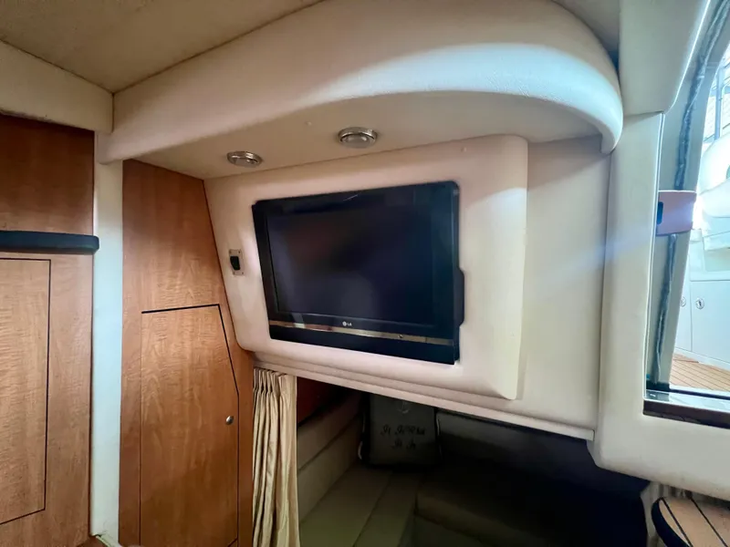 Slide: The Image of Interior of 2006 Sea Ray 340 Sundancer with wall-mounted TV and wood paneling. - 23