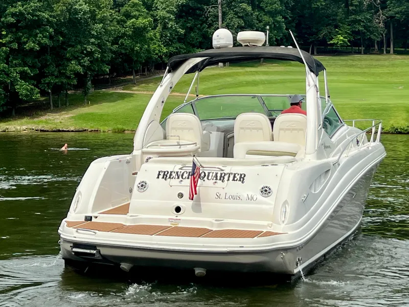 Slide: The Image of 2006 Sea Ray 340 Sundancer boat on water, rear view, with lush green background. - 6