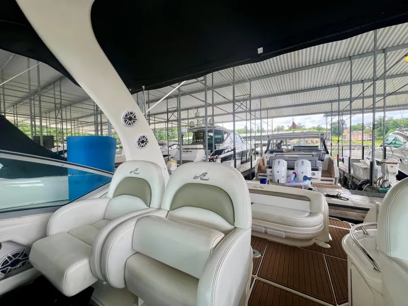 Slide: The Image of 2006 Sea Ray 340 Sundancer interior with white seating, docked in a covered marina. - 9