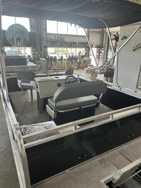 Slide: The Image of 2026 Paddle King LO PRO FISHER boat interior with seating and steering wheel in showroom. - 4