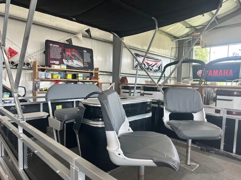 Slide: The Image of 2026 Paddle King LO PRO FISHER pontoon boat interior with seating and canopy in showroom. - 5