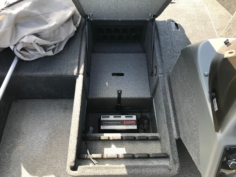 Slide: The Image of 2011 Lund 1775 Impact boat storage compartment with battery charger. - 16